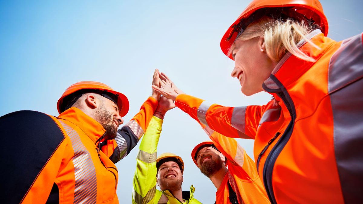 One team gives itself a high five with orange protective clothing.
